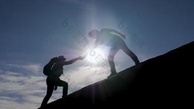 团队精神徒步旅行者互相帮助爬上高山